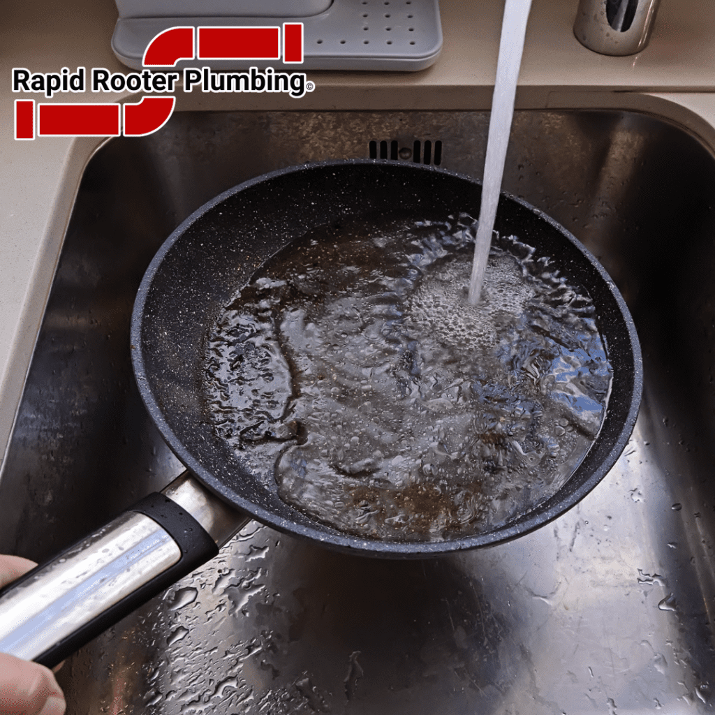 Picture of washing cooking grease down a kitchen sink.